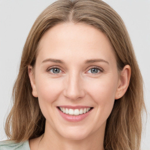 Joyful white young-adult female with long  brown hair and blue eyes