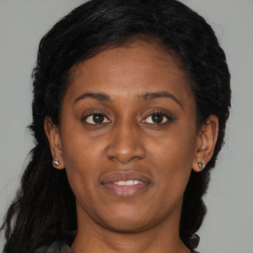 Joyful black young-adult female with medium  brown hair and brown eyes