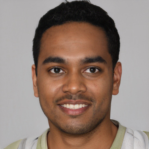 Joyful black young-adult male with short  black hair and brown eyes