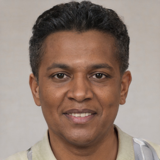Joyful black young-adult male with short  brown hair and brown eyes