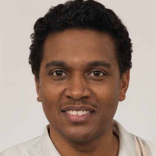 Joyful black young-adult male with short  black hair and brown eyes