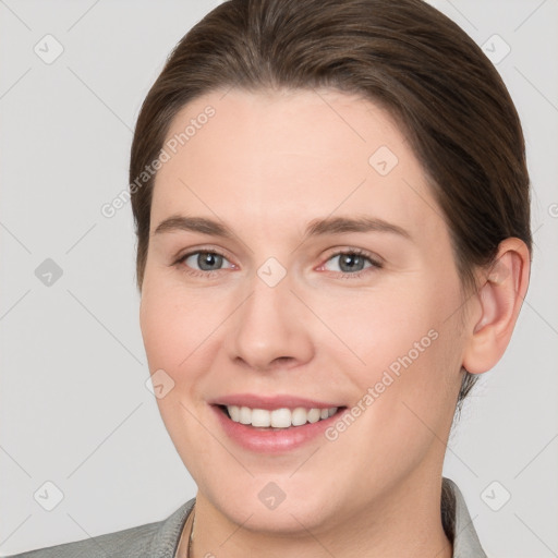 Joyful white young-adult female with medium  brown hair and grey eyes