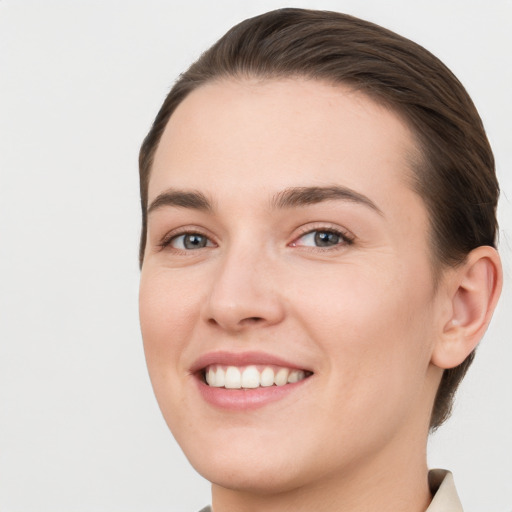 Joyful white young-adult female with short  brown hair and grey eyes