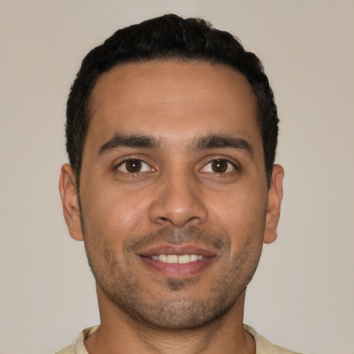 Joyful white young-adult male with short  black hair and brown eyes