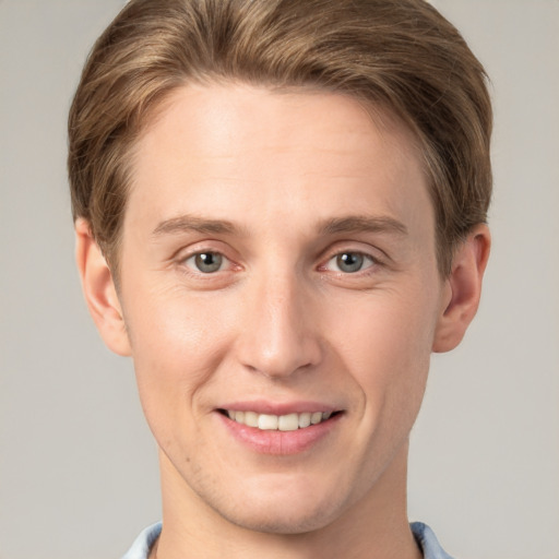 Joyful white young-adult male with short  brown hair and grey eyes