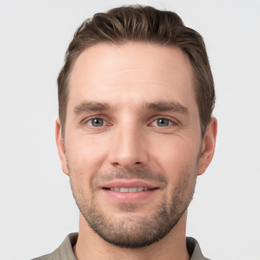 Joyful white young-adult male with short  brown hair and grey eyes