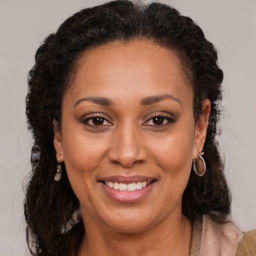 Joyful black young-adult female with long  brown hair and brown eyes