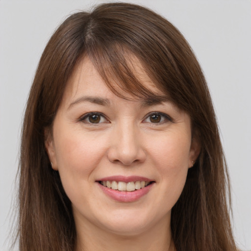 Joyful white young-adult female with long  brown hair and brown eyes