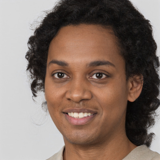 Joyful black young-adult female with long  black hair and brown eyes