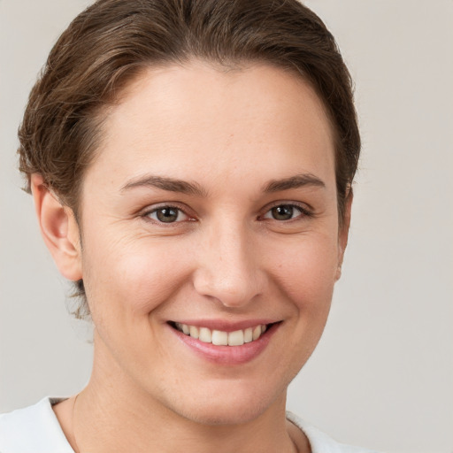 Joyful white young-adult female with short  brown hair and brown eyes