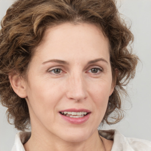 Joyful white adult female with medium  brown hair and green eyes