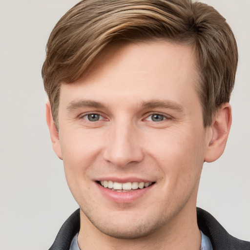 Joyful white young-adult male with short  brown hair and grey eyes