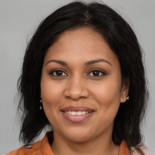 Joyful latino adult female with medium  brown hair and brown eyes
