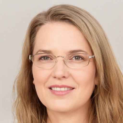 Joyful white adult female with long  brown hair and blue eyes