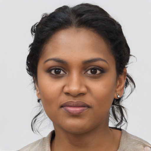 Joyful black young-adult female with long  brown hair and brown eyes