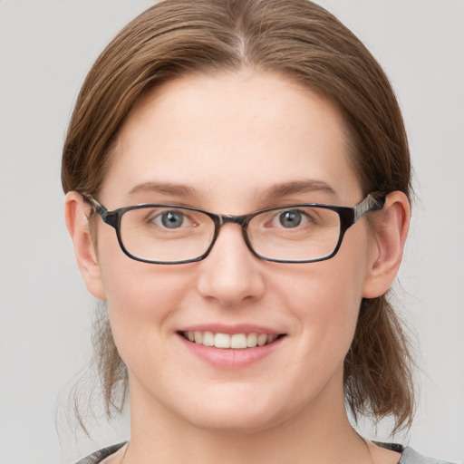 Joyful white young-adult female with medium  brown hair and blue eyes