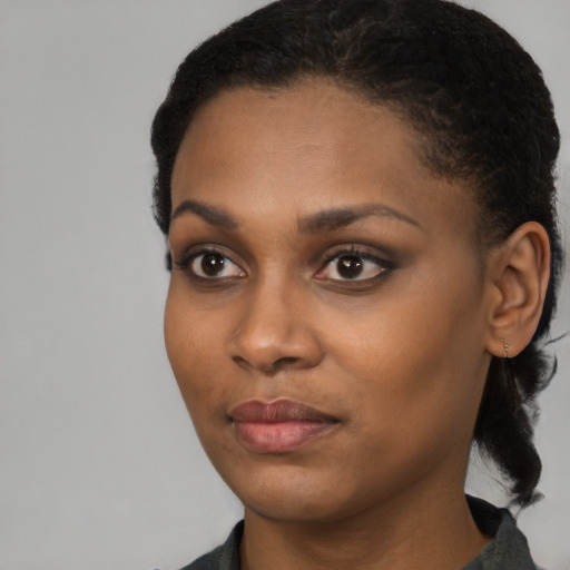 Joyful black young-adult female with short  black hair and brown eyes