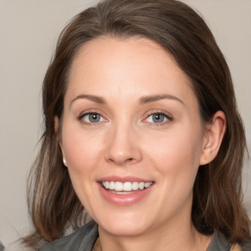 Joyful white young-adult female with medium  brown hair and grey eyes