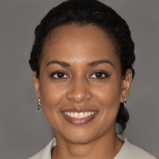 Joyful black young-adult female with short  black hair and brown eyes
