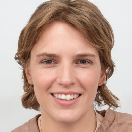 Joyful white young-adult female with medium  brown hair and blue eyes