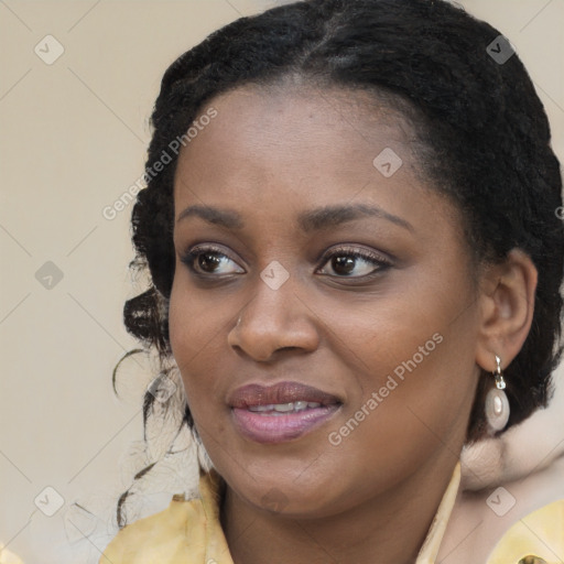 Joyful black young-adult female with long  brown hair and brown eyes