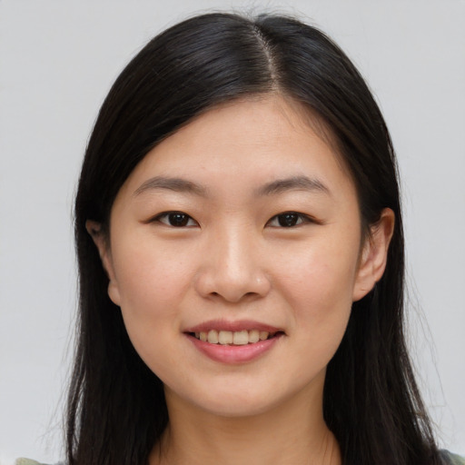 Joyful asian young-adult female with long  brown hair and brown eyes