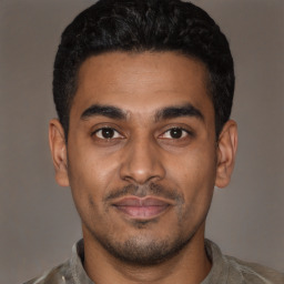 Joyful latino young-adult male with short  black hair and brown eyes