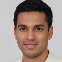 Joyful latino young-adult male with short  black hair and brown eyes