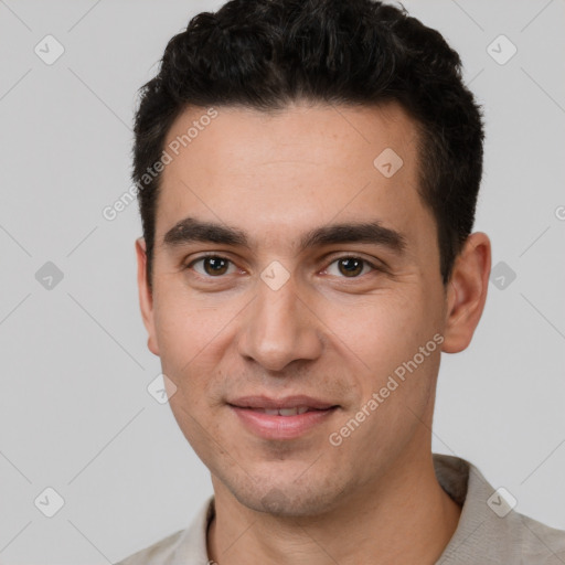 Joyful white young-adult male with short  black hair and brown eyes