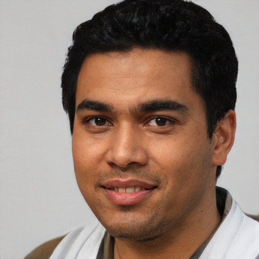 Joyful latino young-adult male with short  black hair and brown eyes