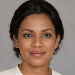 Joyful black young-adult female with medium  brown hair and brown eyes