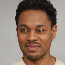 Joyful black young-adult male with short  black hair and brown eyes