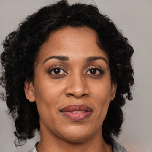 Joyful black adult female with medium  black hair and brown eyes