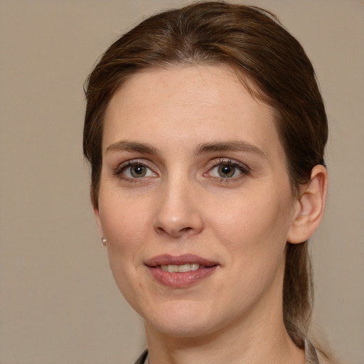 Joyful white adult female with medium  brown hair and grey eyes