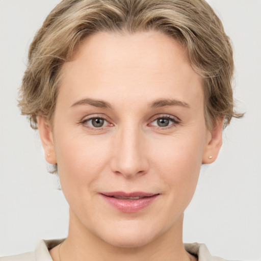 Joyful white young-adult female with short  brown hair and grey eyes