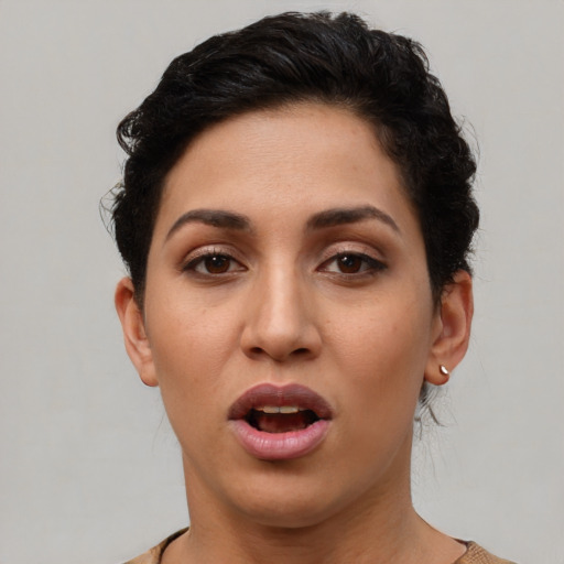 Joyful latino young-adult female with short  black hair and brown eyes