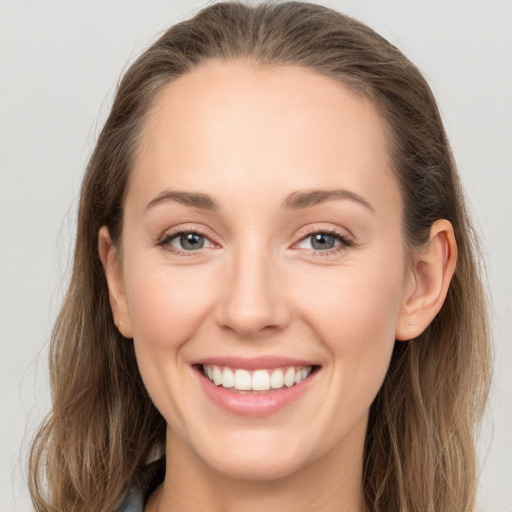 Joyful white young-adult female with long  brown hair and grey eyes