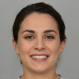 Joyful white young-adult female with medium  brown hair and brown eyes