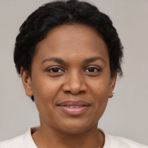 Joyful black young-adult female with short  brown hair and brown eyes