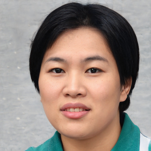 Joyful asian young-adult female with short  black hair and brown eyes