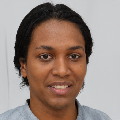 Joyful black young-adult female with short  black hair and brown eyes