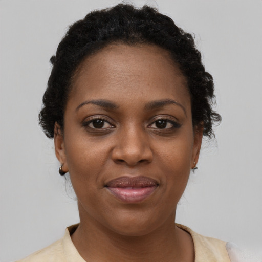 Joyful black young-adult female with short  brown hair and brown eyes