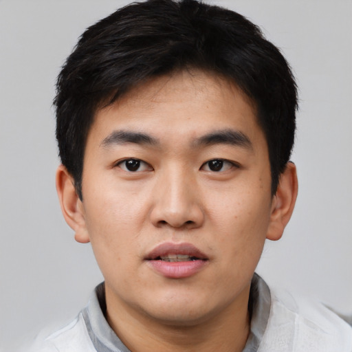 Joyful asian young-adult male with short  black hair and brown eyes