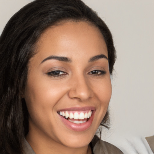 Joyful latino young-adult female with long  brown hair and brown eyes