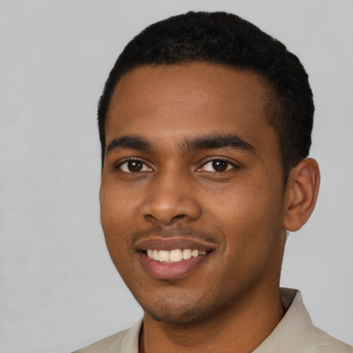 Joyful black young-adult male with short  black hair and brown eyes