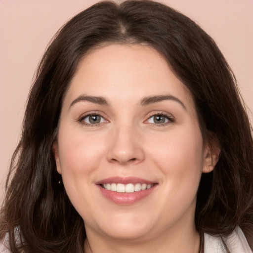 Joyful white young-adult female with long  brown hair and brown eyes