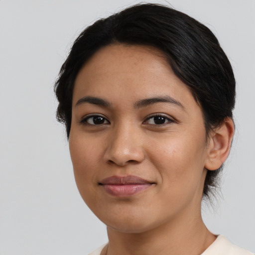 Joyful latino young-adult female with short  black hair and brown eyes