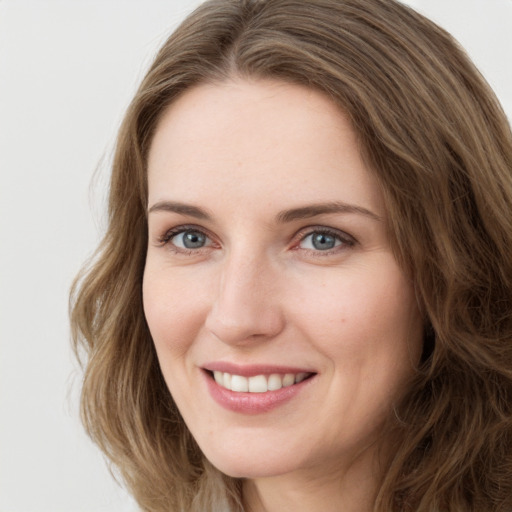 Joyful white young-adult female with long  brown hair and green eyes