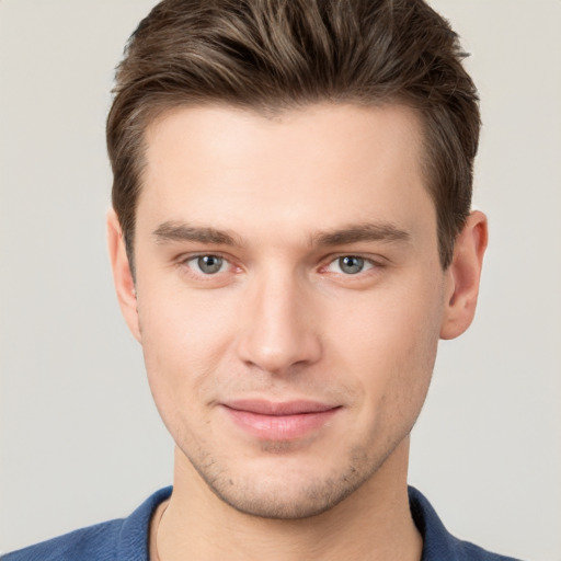 Joyful white young-adult male with short  brown hair and grey eyes