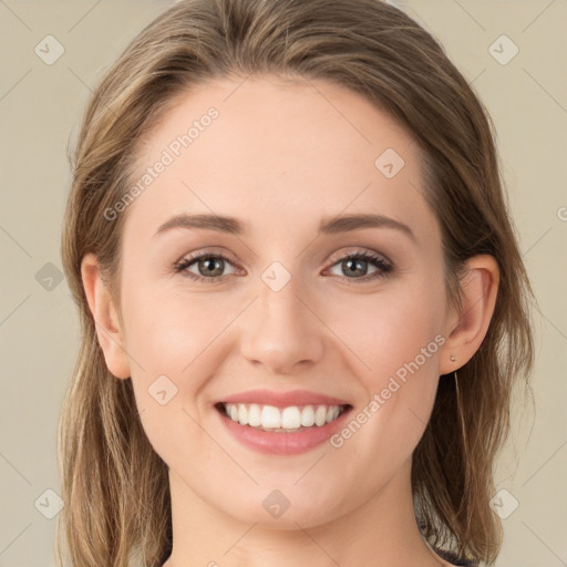 Joyful white young-adult female with long  brown hair and green eyes